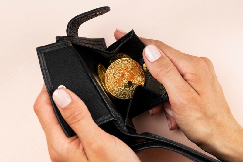 hand opening wallet with bitcoin coin showing self-custody crypto storage concept for Crypto30x.com Trust Wallet.